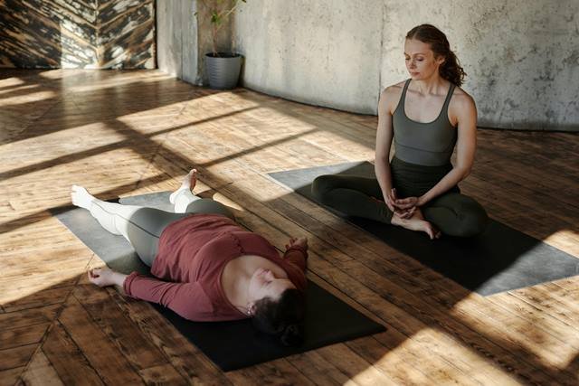 "Woman lying down in a peaceful meditation pose, focusing on relaxation and healing."